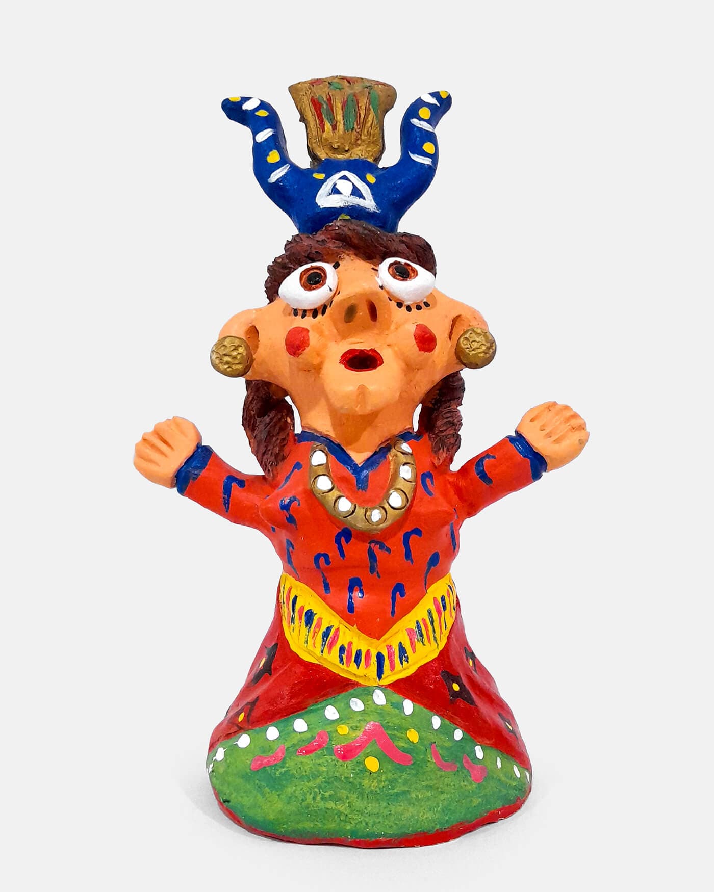 Figura de barro pintada à mão, saia vermelha e verde, com uma figura azul de coroa na cabeça